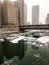 Frozen chunks of ice on Chicago River during heavy snowfall on December afternoon.