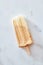 Frozen coffee gelato ice cream on a wooden stick over marble background, top view. Summer delicious desserts
