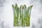 Frozen cold asparagus on a old kitchen table. White background. Top view