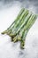 Frozen cold asparagus on a old kitchen table. White background. Top view