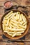 Frozen Crinkle oven French fries potatoes sticks in a wooden plate. Wooden background. Top view