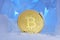 Frozen crypto currency bitcoin face obverse stands surrounded by blue ice in beautiful light.