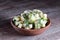 Frozen cubes of zucchini in a bowl on the wooden background