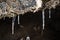 Frozen dripping water on the stone entrance of antique cave in winter