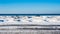 Frozen dunes on beach against water and sky.