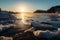 frozen fiord, with view of the sun rising over the horizon, casting warm light on its icy surface