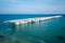 Frozen fishing pier with hanging icicles in a sunny winter day