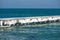 Frozen fishing pier with hanging icicles in a sunny winter day