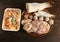 Frozen foods on a wooden table. Frozen pelengas, herring, beef and meatball steaks, zurna corn, beans, peas and carrot pieces