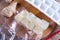 Frozen ginger cubes in a bug on a cutting board on a wooden table