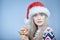 Frozen girl with snow on face wearing Santa hat with martini glass