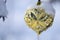 Frozen Golden Christmas Ornament Decorating a Snowy Outdoor Tree