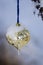 Frozen Golden Christmas Ornament Decorating a Snowy Outdoor Tree