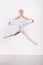 Frozen grace. a young ballerina energetically leaping across the floor of a dance studio.