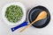 Frozen green beans in plate, spoon in frying pan