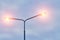 Frozen with hanging icicle, burning street lamp against background cloudy evening sky