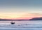 Frozen ice surface on lake with sunset backdrop. Aerial pattern