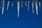 Frozen Icicles on Blue Sky Background