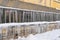 Frozen icicles hanging from roof on glasshouse. Snow melting during early spring and snowbreak