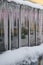 Frozen icicles hanging from roof on glasshouse. Snow melting during early spring and snowbreak