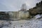 Frozen Jagala waterfall with icicles hanging from rocks, view from below, Estonia