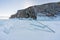 Frozen lake Biakal in Siberia, Russia. Cracked ice on snow floor with mountain in winter