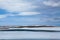 Frozen lake next to Highway 1 in Iceland with changing clouds in the sky