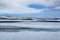 Frozen lake next to Highway 1 in Iceland with changing clouds in the sky