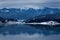 Frozen lake and pine trees in snow at Colibita. Romania early morning winter scen