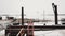 Frozen lake shore, rusted pier covered in snow, ruined building