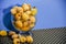 Frozen loquats Eriobotrya japonica in glass bowl on lilac background