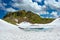 Frozen mountain lake among the snow-covered rocky slopes.