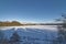 A Frozen over Loch Clunie on a Winters evening with long shadows over the ice covered loch.