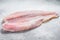 Frozen pangasius fish fillet. Gray background. Top view