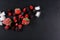 Frozen raspberry, blackberry, strawberries, pieces of ice on a black shale board, frozen fruit, top view, close up, place for text