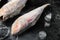Frozen red mullet or barabulka raw fish, on black dark stone table background