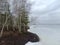 Frozen Rekyva lake and forest during cloudy winter day