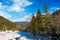 Frozen river in forested mountains