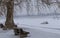 Frozen river in ice, fishing boat, promenade bench