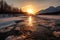 frozen river, with mountains in the background, and sun setting behind the horizon