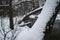 A frozen river in a wintry landscape. Winter landscape with cloudy sky and sun.