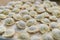 Frozen russian crude pelmeni laid out on a wooden board.