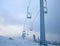 Frozen ski lift covered with frost on gloomy day in snowy mountains, path extending beyond the horizon