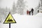 Frozen snowmobile sign and fogy, snowy background with walking family