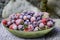 Frozen strawberries, black currants, blueberries, gooseberries, covered with hoarfrost on a gray background. Close-up