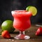 Frozen strawberry margarita garnished with a salt rim and a lime slice on dark background. Margarita with crushed ice. Summer red