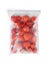 Frozen tomatoes in plastic bag on white, top view. Vegetable preservation