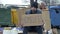 Frozen untidy young man sits by a pile of rubbish and holds a handwritten HOMELESS poster.