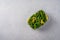 Frozen vegetables green pods beans in plastic tray on an gray background, top view