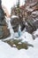 Frozen waterfall in the bed of the Kyngyrga mountain river in early spring. Arshan resort, Republic of Buryatia, Russia, Siberia